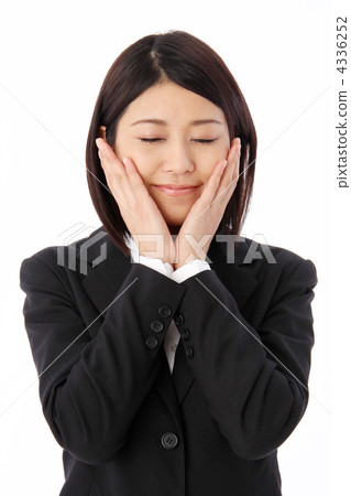 A woman in a suit with her eyes closed and touching his cheeks with both hands A woman in a suit with her eyes closed and touching his cheeks with both hands 4336252