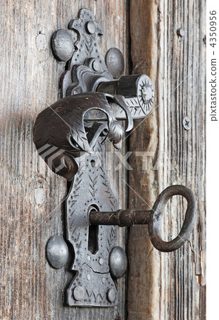 Vintage metal handle and key at wooden door 4350956