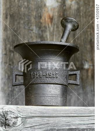 Ancient kitchen and medical utensil. Old metal mortar on wooden 4350957