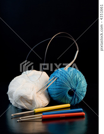 colorful yarn balls with needles and knitting hooks over black 4351661