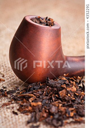 Macro of smoking pipe and tobacco on linen canvas background Macro of smoking pipe and tobacco on linen canvas background 4352291
