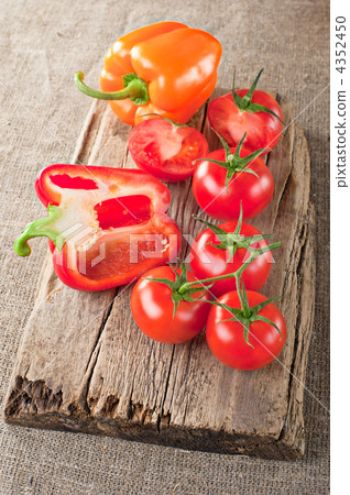 Fresh tomato, paprika and vintage wooden cutting board on canvas Fresh tomato, paprika and vintage wooden cutting board on canvas 4352450