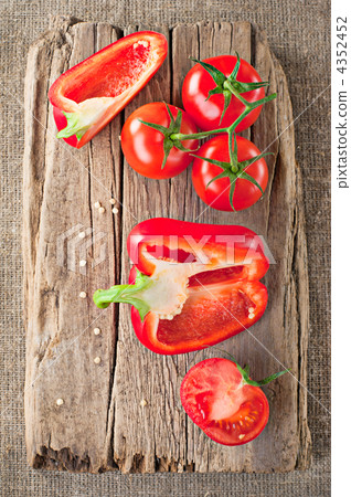 Fresh tomato, red paprika and vintage wooden cutting board on ca Fresh tomato, red paprika and vintage wooden cutting board on ca 4352452