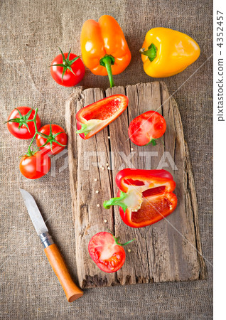 Fresh tomato, paprika, steel knife and vintage wooden cutting bo Fresh tomato, paprika, steel knife and vintage wooden cutting bo 4352457