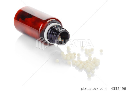 Bottle and globule of homeopathic medication on white background Bottle and globule of homeopathic medication on white background 4352496