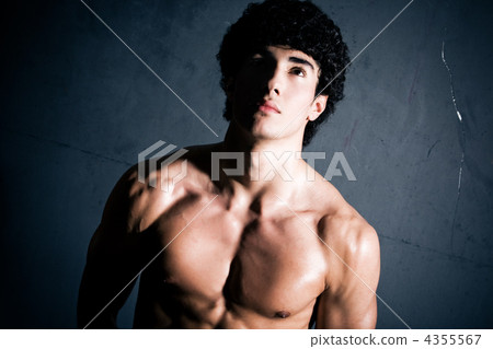 Young muscular man on wall background 4355567