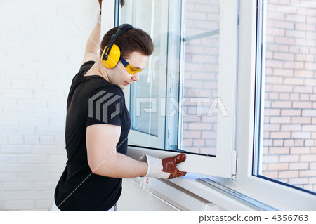 Man worker mounting window Man worker mounting window 4356763