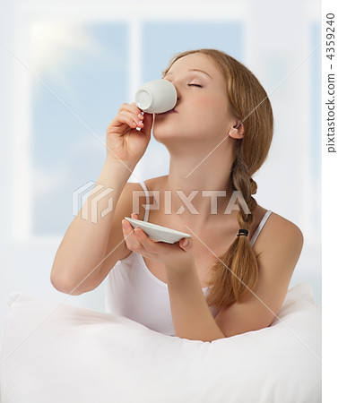Young beautiful woman drinking coffee in bed Young beautiful woman drinking coffee in bed 4359240