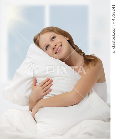 dreamy beauty girl hugging a pillow while sitting in bed dreamy beauty girl hugging a pillow while sitting in bed 4359241