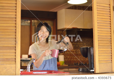 A woman who puts coffee in the kitchen A woman who puts coffee in the kitchen 4393673