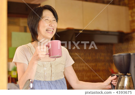A woman who puts coffee in the kitchen A woman who puts coffee in the kitchen 4393675