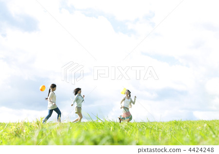 跑一個氣球的三名婦女在草甸 4424248