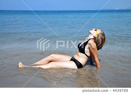 Young girl sitting on the beach. Young girl sitting on the beach. 4439789