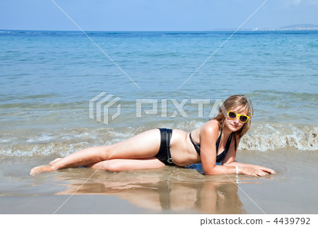 Young girl sitting on the beach. Young girl sitting on the beach. 4439792