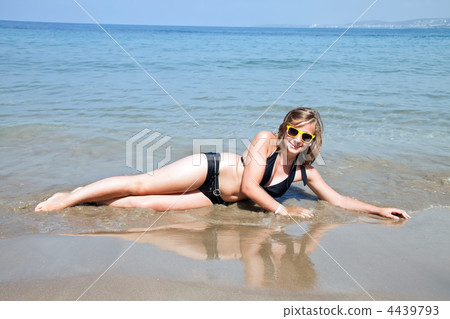 Young girl sitting on the beach. Young girl sitting on the beach. 4439793