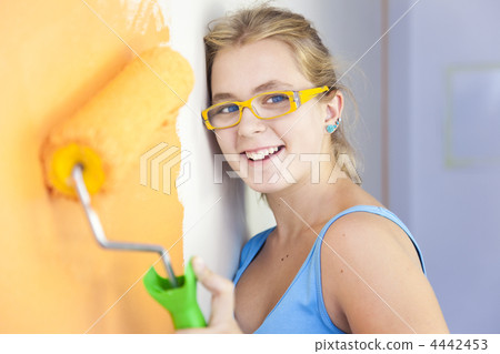 happy young woman painting a wall in  her room /  colorful life happy young woman painting a wall in  her room /  colorful life 4442453