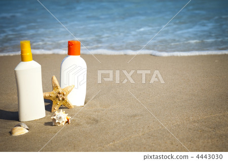 Suntan Lotion Flacons on the Beach with copy space 4443030