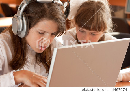 Two schoolgirls concentrated on their task with notebook Two schoolgirls concentrated on their task with notebook 4467674