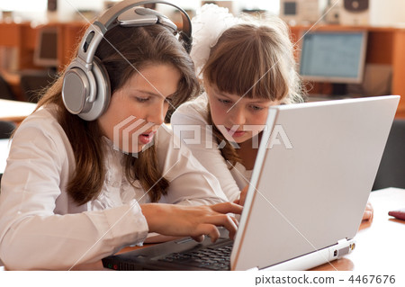 Two schoolgirls performs task using notebook 4467676