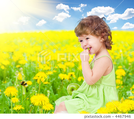 Baby girl sitting among dandelion with healthy food apple in her Baby girl sitting among dandelion with healthy food apple in her 4467946