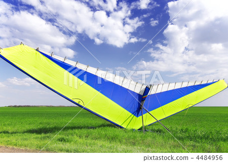 Motorized hang glider over green grass 4484956