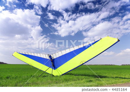 Motorized hang glider over green grass Motorized hang glider over green grass 4485164