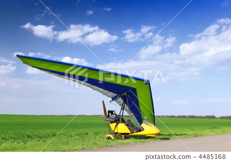 Motorized hang glider over green grass Motorized hang glider over green grass 4485168