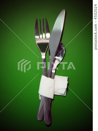 Table serving-knife,spoon,fork on green backdrop. Table serving-knife,spoon,fork on green backdrop. 4502024