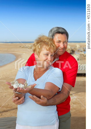 Elderly couple on the coast ,holding corals. 4511830