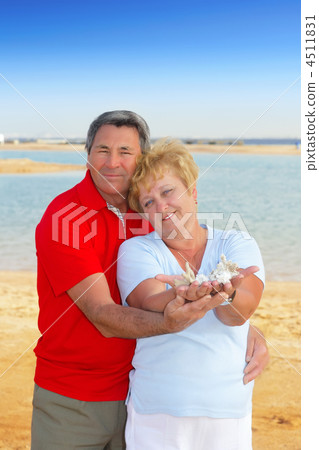 Elderly couple on the coast ,holding corals. Elderly couple on the coast ,holding corals. 4511831