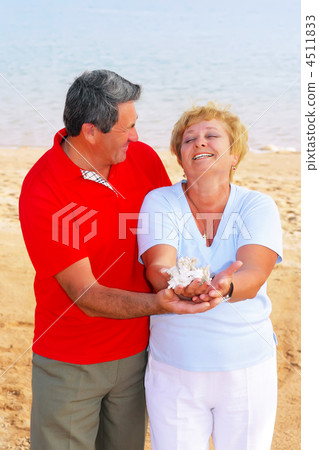 Elderly couple on the coast ,holding corals. 4511833