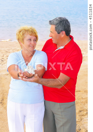 Elderly couple on the coast ,holding corals. 4511834