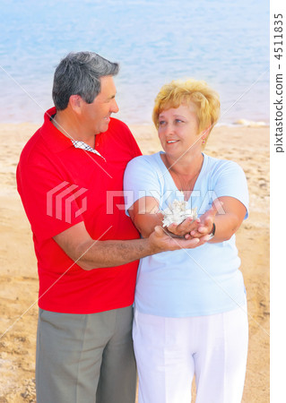 Elderly couple on the coast ,holding corals. 4511835