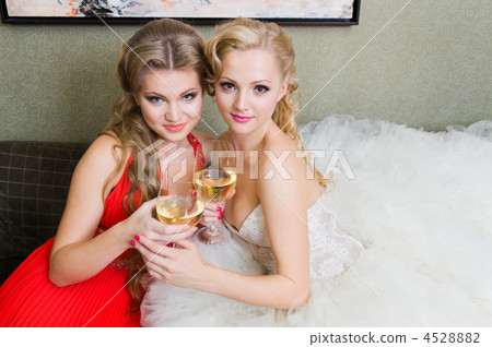 The bride and her bridesmaid with a glass of wine 4528882