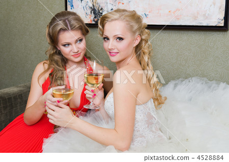 The bride and her bridesmaid with a glass of wine The bride and her bridesmaid with a glass of wine 4528884