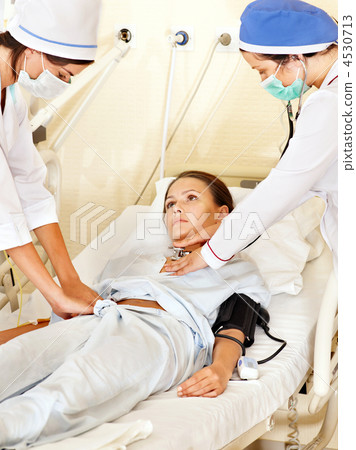 Doctor treats female patient with stethoscope. 4530713