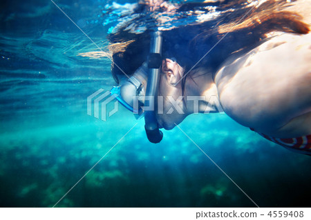 Woman and coral fish in blue water. 4559408