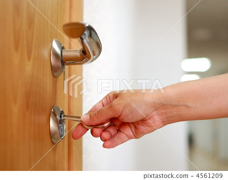 Locking up or unlocking door with key in hand 4561209