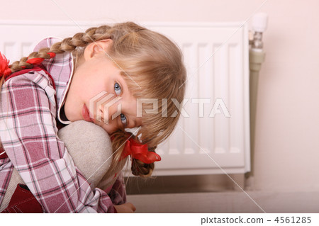 Sad girl sitting near heater. Children problem. 4561285