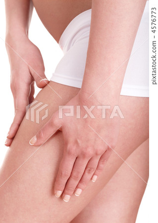 Young woman applying cosmetic cream on leg. 4576773