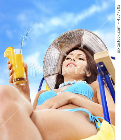 Girl in bikini drinking orange juice. Girl in bikini drinking orange juice. 4577202