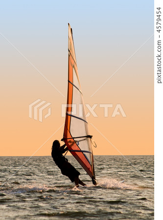 Silhouette of a windsurfer on a gulf 4579454