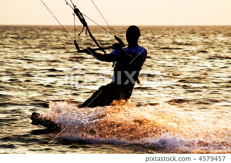 Silhouette of a kitesurfer on a waves Silhouette of a kitesurfer on a waves 4579457