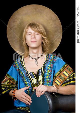 The young man plays a drum over black The young man plays a drum over black 4579829