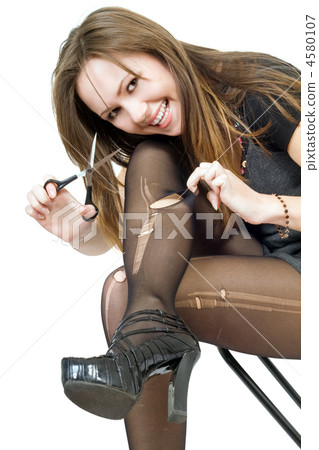 Smiling girl with scissors cuts the stockings. Isolated 4580107