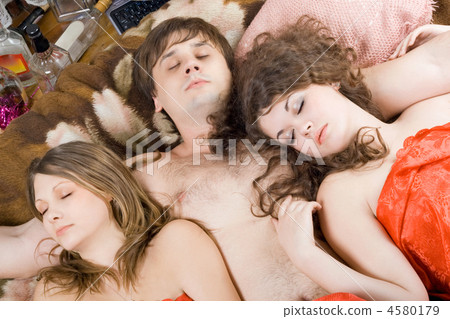 Sleeping young man and two women after a party Sleeping young man and two women after a party 4580179