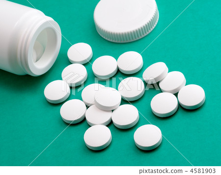 Pill from prescription bottle on green background 4581903