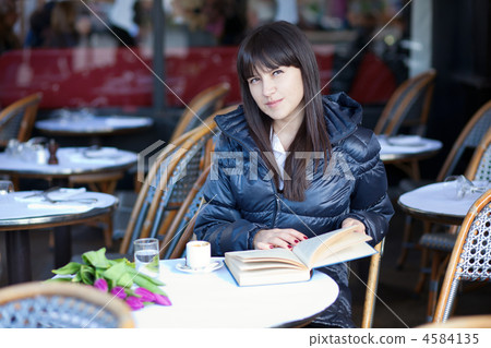 Dark-haired beautiful woman with book in Parisian street cafe 4584135