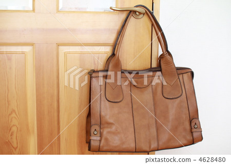 Camel leather bag hanging from a doorknob Camel leather bag hanging from a doorknob 4628480