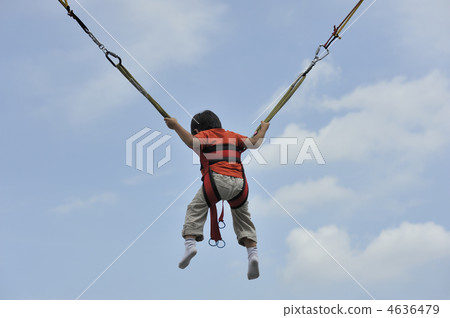 A boy playing a bungee trampoline 4636479
